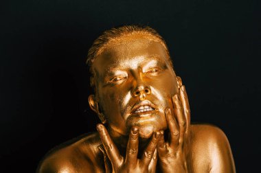 Altın boyayla kaplanmış genç ve güzel bir kadının resmi.