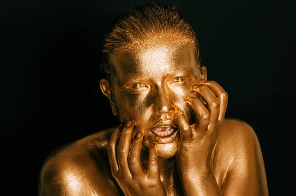 Altın boyayla kaplanmış genç ve güzel bir kadının resmi.