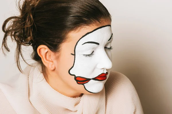 Woman actress with double face makeup studio portrait