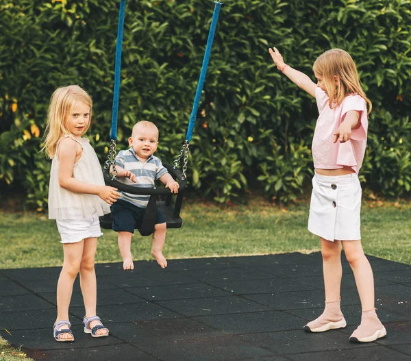 3个孩子的家人一起在外面玩耍 大姐姐照顾弟弟 — 图库照片
