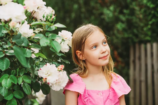 一个可爱的小女孩在户外的夏季画像 一个带着玫瑰的花园里快乐美丽的孩子 — 图库照片