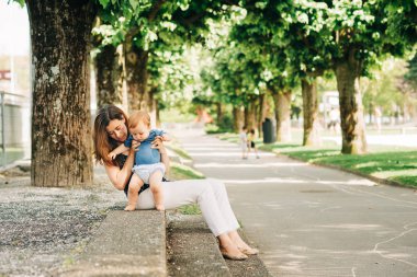 Mutlu anne çocuklarla yaz parkında vakit geçiriyor, bebekle oynuyor.