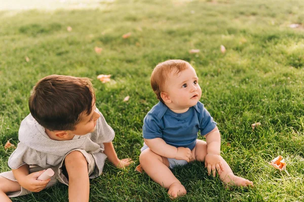 かわいいです幼児男の子遊び外で可愛いです赤ちゃんの弟 子供たち遊びで夏の公園 — ストック写真