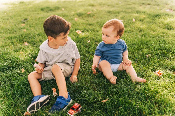 可爱的小孩在外面和可爱的小弟弟玩耍 小孩子在夏天的公园里玩耍 — 图库照片