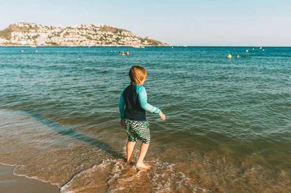 有趣的小男孩在海边玩耍 穿着防晒皮疹背心 和孩子们一起度暑假 回顾往事 — 图库照片