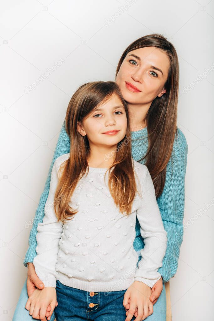 Studio portrait of cute little girl with her mom