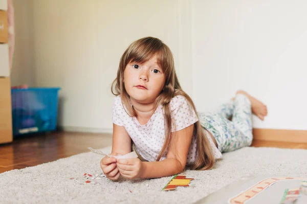 一个聚精会神的小女孩在房间里玩纸 — 图库照片