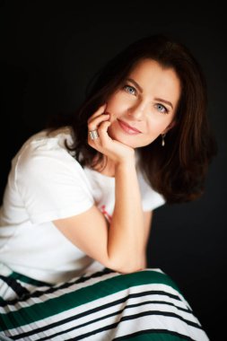 Çekici gülüşlü güzel bir kadının stüdyo portresi.