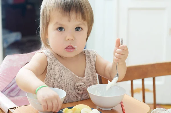 Küçük kız bebek çocuk ekşi krema yeme oturma, yemek — Stok fotoğraf