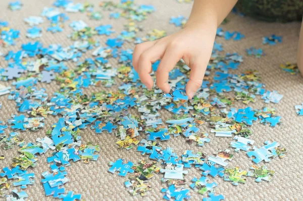 Child hand taking puzzle piece — Stock Photo, Image