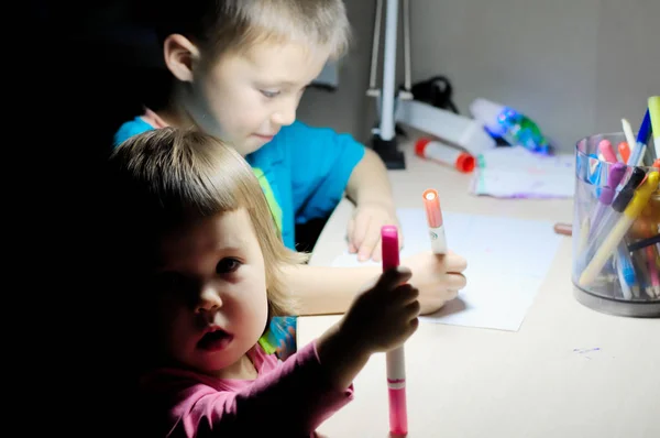 Брат і сестра малюють вечірній будинок, високий ISO — стокове фото