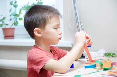 oğlan masanın üzerinde erken beyin geliştirme kağıt ile işçiliği