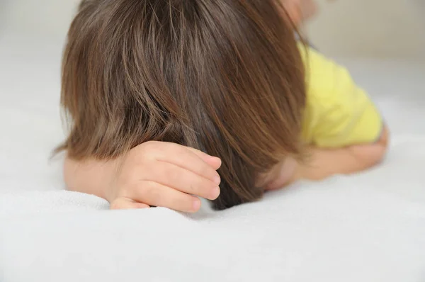 Child hiding face lying on bed, crying  offended little girl — Stock Photo, Image