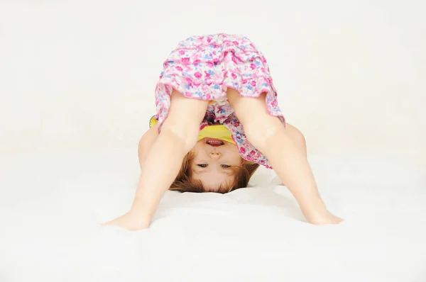 Sorridente bambina in piedi sulla testa a testa in giù isolato — Foto Stock