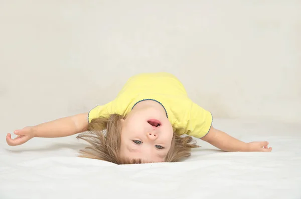 Bambino sdraiato sul retro rendendo arco isolato — Foto Stock