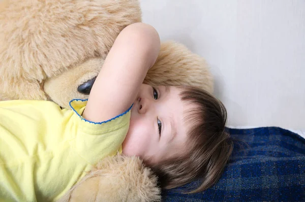 Kind spielt mit Teddybär-Spielzeug drinnen, glückliche Kindheit, lächelndes Kind hat Spaß — Stockfoto