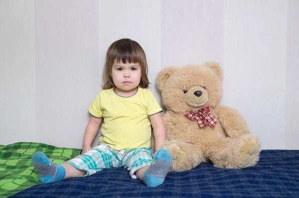 Niño sentado con osito de peluche juguete grande, concepto de amistad infantil — Foto de Stock