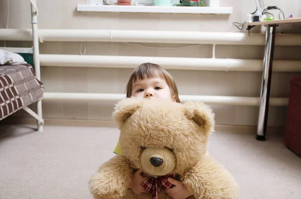 Kind knuffelen teddybeer, toewijding concept, jong geitje verstopt achter het speelgoed Rechtenvrije Stockafbeeldingen