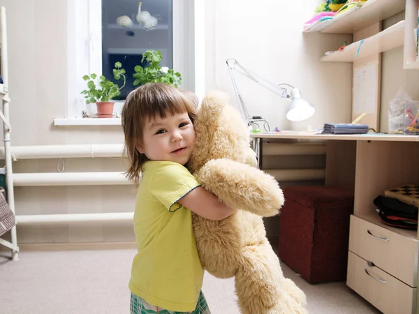 Kind speelgoed teddybeer overdekt, gelukkige kindertijd concept, knuffelen glimlachend schattige babymeisje spelen met speelgoed Stockfoto