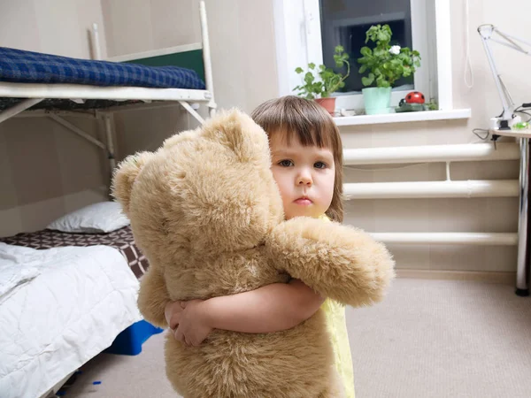 Niño abrazando juguete osito de peluche interior en su habitación, concepto de devoción, interior de la habitación de los niños — Foto de Stock