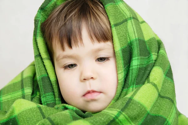 Portrait d'enfant dans le réchauffement de couverture, garde d'enfants, petite fille enveloppée dans une couverture chaude verte, concept d'hiver confortable — Photo