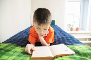 Yatak, Çocuk eğitimi, çocuk portre üzerinde kitap ile eğitim kavramı, yalan kitap okuma çocuk hikaye kitabı ilginç