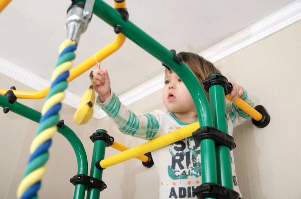 Kind klimmen aan banana op gymnastische bar. Kinderen de training. Kind gezondheidszorg en fysieke training concept. Gelukkig en gezond jeugd. Kind spelen jungle monkey Rechtenvrije Stockafbeeldingen