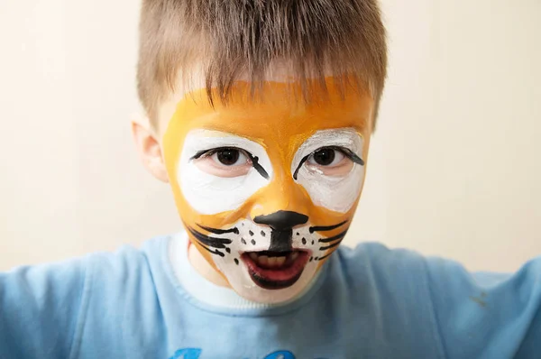 子供の顔の絵。少年はメイクアップ アーティストによってトラや、凶暴なライオンとして描かれました。演劇の準備。少年俳優の果たした役割。タイガー マスク顔 — ストック写真