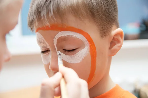 Make up artist making tiger mask for child.Children face painting. Boy  painted as tiger or ferocious lion. Preparing for theatrical performance. Boy actor playing role. Tiger mask face — Stock Photo, Image