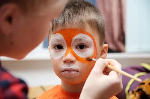 Make up artist making tiger mask for child.Children face painting. Boy  painted as tiger or ferocious lion. Preparing for theatrical performance. Boy actor playing role. Tiger mask face — Stock Photo, Image