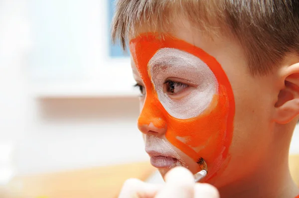 Make up artist making tiger mask for child.Children face painting. Boy  painted as tiger or ferocious lion. Preparing for theatrical performance. Boy actor playing role. Tiger mask face — Stock Photo, Image