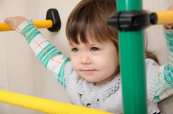 Kinderen thuis training. Meisje op gymnastische balk. Kind gezondheidszorg en fysieke training concept. Gelukkig en gezond jeugd. Kid op rekstok. Stockafbeelding