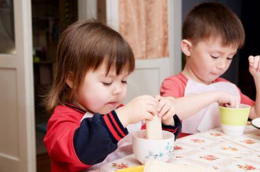 children eating lunch at home, healthy food concept, kids enjoying bread and yogurt, sibling emotional faces, healthy breakfast for brother and sister clipart