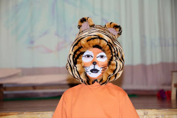 tiger costume for school performance. mask for child.Children face painting. Boy  painted as tiger or ferocious lion. Boy actor playing role. theatrical tiger mask face. School activity