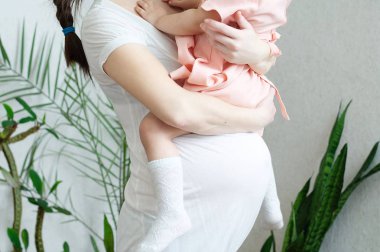 Kızı, gebelik göbek olan çocuk kadın hamile kadınlarla. Mutlu annelik. Bebek doğum üçüncü üç aylık dönemde bekliyor, anne olmak. Çocuk doğum için hazırlanan doğum öncesi dönem, gebelik sağlık