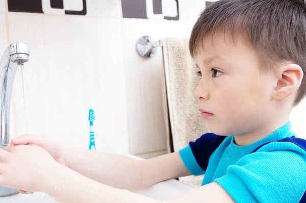 手子個人の健康管理、衛生観念、子供の健康的なライフ スタイルの浴室洗面台で手を洗うを洗う少年 ストックフォト