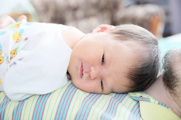 Smiling newborn baby lying on father — Stock Photo, Image