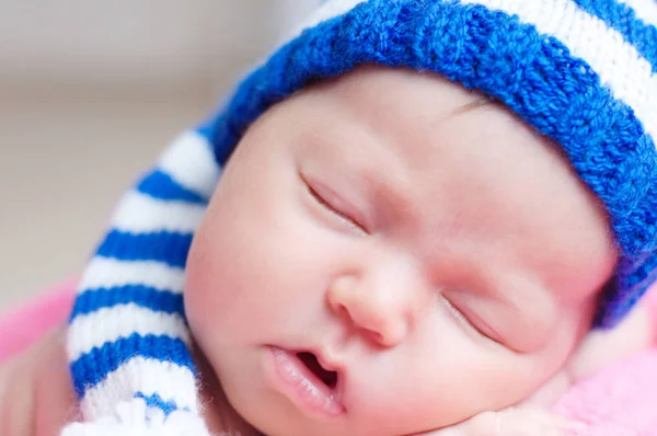 Lindo bebé recién nacido en azul rayas gorra de punto durmiendo. Retrato de bebé durmiendo . — Foto de Stock