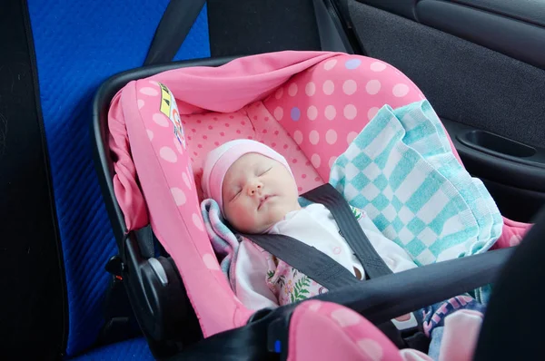 Yenidoğan araba koltuğuna uyuyor. Emniyet konsepti. Kız bebek bebek. çocuklarla sürüş güvenliğini sağlayın. Bebek bakım yaşam tarzı. Şirin Bebek arabasında uyuyan.