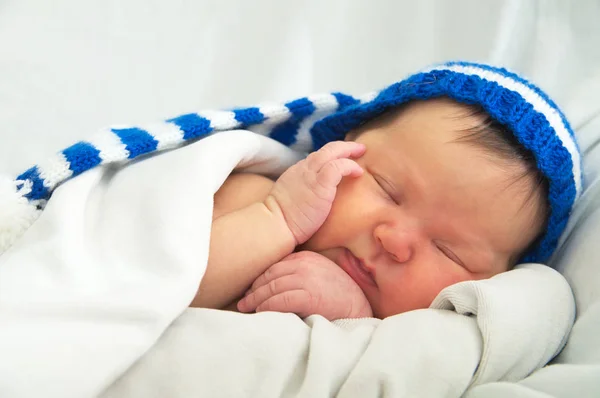 快乐宝贝脸上戴着帽子，新生儿黄疸婴儿保健概念的白色毯子上 — 图库照片