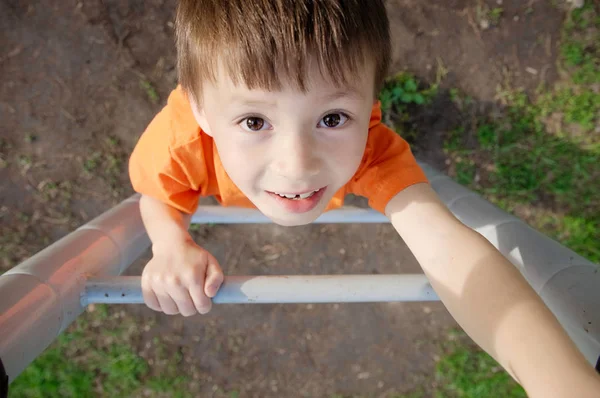 Boy climbing stairs and playing outdoors on playground, children activity. Child portrait from above. Active healthy childhood concept — Stock Photo, Image