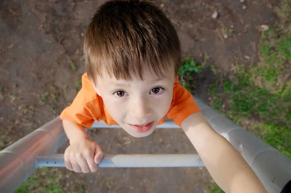 階段を登ると屋外の遊び場、子ども達の遊び活動の少年。上から子供のポートレート。アクティブ健康小児コンセプト ロイヤリティフリーのストック写真