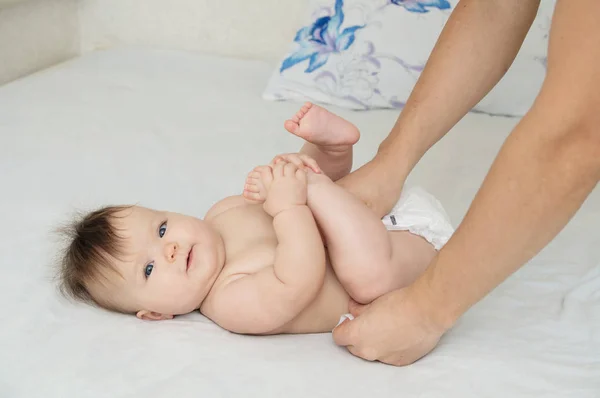 Dad changing diaper on baby girl on bed, changing nappy, everyday care — Stock Photo, Image