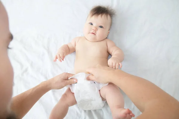 Papá cambiando pañales en la niña en la cama, cambiando pañales, cuidado diario. Vista superior . — Foto de Stock