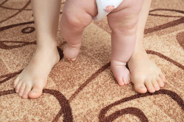 Mother and baby legs stepping. First steps. — Stock Photo, Image