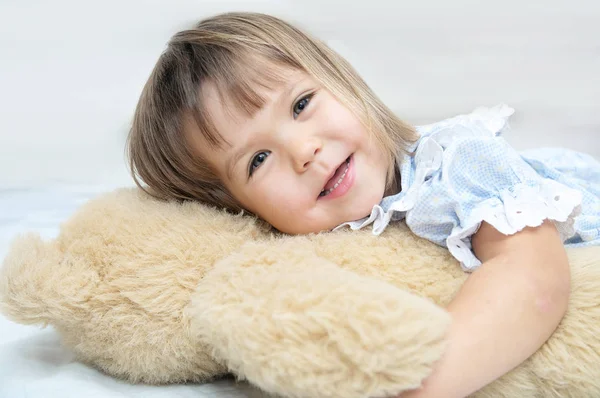 Menina pequena retrato feliz sorrindo com Teddy urso abraçando brinquedo — Fotografia de Stock