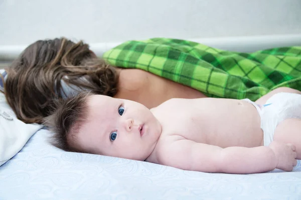 Sleeping parent and baby waking up in the morning lying on bed together, happy family — Stock Photo, Image