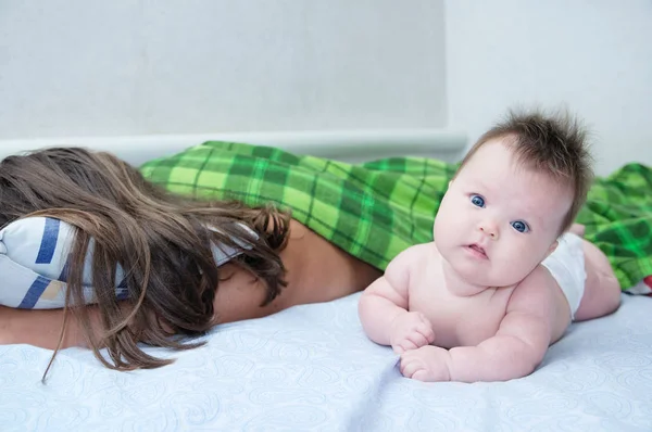 Parent endormi et bébé se réveillent le matin couchés sur le lit ensemble, famille heureuse — Photo