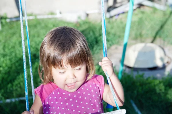 Liten flicka som leker på gungbräda utomhus på sommaren, barn aktivitet — Stockfoto