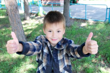 Küçük çocuk göster başparmak yukarı işareti at yaz içinde Park